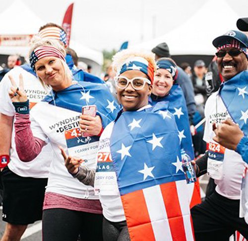 Cheerful race participants posing for a group picture during WWP’s Carry Forward 5K.